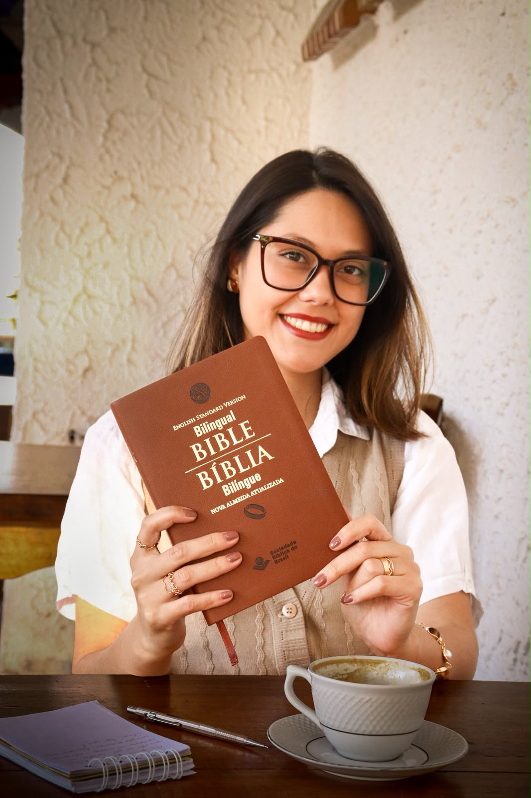 Stephany Guimarães segurando uma Bíblia e um caderno de estudos